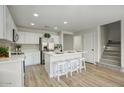Modern kitchen featuring white cabinets, stainless steel appliances, quartz countertops, and a center island with seating at 2676 E Mineral Park Rd, San Tan Valley, AZ 85143