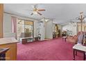 Open living room with red carpet, ceiling fans, and sliding glass doors at 2956 E Sequoia Dr, Phoenix, AZ 85050