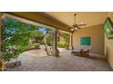Covered patio with ceiling fan, TV, desert landscaping, and stone pavers for ultimate relaxation at 36813 N 109Th Way, Scottsdale, AZ 85262