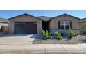 Charming single-story home with a dark garage door, desert landscaping, and neutral colored facade at 37174 W La Paz St, Maricopa, AZ 85138