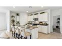 Bright kitchen featuring white cabinets, stainless steel appliances, an island with bar seating and stone countertops at 48401 N Duran Way, Gold Canyon, AZ 85118