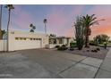 Single-story home showing desert landscaping, driveway, and garage at sunset at 6119 E Sandra Ter, Scottsdale, AZ 85254