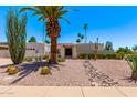 Charming home featuring desert landscaping with a large palm tree and rock accents at 6119 E Sandra Ter, Scottsdale, AZ 85254