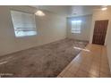 Spacious living room with tile entry and carpet floors; ready for your personal touch at 6820 S 68Th Ln, Laveen, AZ 85339