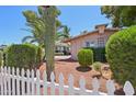Desert landscaping with mature cactus and palm tree behind a white picket fence at 8637 E Solano Dr, Scottsdale, AZ 85250