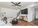 Cozy living room with hardwood floors, staircase and large screen television at 9050 N 51St Ln, Glendale, AZ 85302