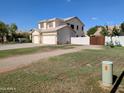 View of the side of the home showing a three car garage and partial driveway at 1015 S 132Nd St, Gilbert, AZ 85233