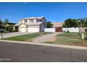 A two story home with a three car garage and extended drive way sits under a clear blue sky at 1015 S 132Nd St, Gilbert, AZ 85233