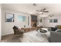 Comfortable living room with brick fireplace, ceiling fans, and a cozy seating area at 1028 W 5Th St, Mesa, AZ 85201