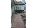 Inviting front entrance with a brick pathway, garden bed, large window and manicured shrubbery at 1044 N Arvada N --, Mesa, AZ 85205