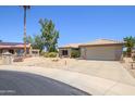Eye-catching one-story home featuring desert landscaping and a beige exterior with a two-car garage at 15658 W Arbor Trl, Surprise, AZ 85374