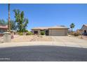 Attractive one-story home featuring desert landscaping, a beige exterior, and a two-car garage at 15658 W Arbor Trl, Surprise, AZ 85374