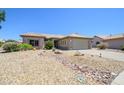 Inviting single-story home featuring desert landscaping and a beige exterior with a two-car garage at 15658 W Arbor Trl, Surprise, AZ 85374