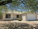 Lovely single-story home featuring a well-manicured front yard, desert landscaping and a two-car garage at 1918 S Ocotillo Dr, Apache Junction, AZ 85120