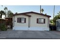 Charming single-story home featuring cream siding, red trim, a concrete driveway, and desert landscaping at 2060 N Center St # 275, Mesa, AZ 85201