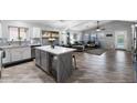 Open concept kitchen with island and built-in beverage cooler flowing into the living room at 2111 E Rawhide St, Gilbert, AZ 85296