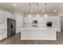 Modern kitchen boasts white cabinets, stainless appliances, quartz countertops, decorative backsplash, and stylish pendant lights at 22944 E Via Del Oro --, Queen Creek, AZ 85142