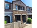 Inviting townhome exterior featuring stone accents, covered entry, and well-manicured shrubbery at 2323 E Huntington Dr, Phoenix, AZ 85040