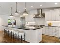 Modern kitchen features a large island with seating, stainless steel appliances, and white cabinetry at 3817 E Highland Ave, Phoenix, AZ 85018