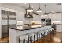 Bright kitchen boasts a large island with seating, stainless steel appliances, and sleek white cabinets at 3817 E Highland Ave, Phoenix, AZ 85018