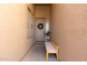 Inviting front porch with neutral wall paint, a wooden bench and a welcome mat at 4064 E Reins Rd, Gilbert, AZ 85297