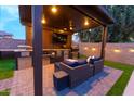 Custom outdoor kitchen with granite counters, built-in grill, TV, and wicker furniture at 4064 E Reins Rd, Gilbert, AZ 85297