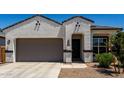 Beautiful front exterior featuring desert landscaping, two-car garage, and a covered entry at 40918 W Hillman Dr, Maricopa, AZ 85138