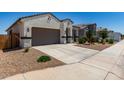 Charming single-story home featuring desert landscaping, a two-car garage, and a welcoming entrance at 40918 W Hillman Dr, Maricopa, AZ 85138