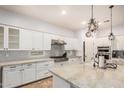 Bright kitchen with white cabinetry, stainless steel appliances, granite countertops, and chandelier lighting at 4453 S Huachuca Way, Chandler, AZ 85249