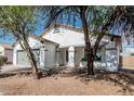 Charming single-story home featuring a gray two-car garage, desert landscaping, and a well-maintained front yard at 513 S 115Th Dr, Avondale, AZ 85323