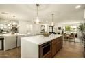 Open-concept kitchen with a large island, modern lighting, and seamless flow into the dining and living areas at 7618 N Via Del Paraiso --, Scottsdale, AZ 85258
