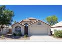 Charming single-story home with desert landscaping, arched entry, and attached two-car garage at 8343 W Audrey Ln, Peoria, AZ 85382