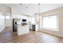 Modern kitchen with stainless steel appliances, white cabinetry, an island and a view to the dining area at 8343 W Audrey Ln, Peoria, AZ 85382