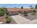 Attractive single-story home featuring a two-car garage, tile roof, and desert landscaping for low maintenance at 9263 W Oraibi Dr, Peoria, AZ 85382