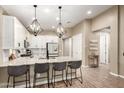 Open kitchen features a large center island, pendant lighting, stainless appliances, and white cabinets at 9624 E Thunderbolt Ave, Mesa, AZ 85212