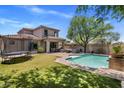 Large backyard with pool, patio seating, and artificial grass, perfect for outdoor enjoyment at 9904 E South Bend Dr, Scottsdale, AZ 85255