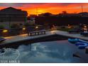 Beautiful backyard pool at sunset featuring modern landscaping, lighting, and outdoor seating at 1100 S 176Th Ave, Goodyear, AZ 85338