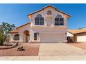 Two-story home featuring a terra cotta-colored roof, white stucco, arched windows, and a two-car garage at 1202 E Libby St, Phoenix, AZ 85022