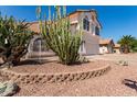 Landscaped front yard featuring desert vegetation, including cacti, rock mulch, and low brick wall at 1202 E Libby St, Phoenix, AZ 85022