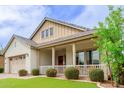Inviting single-Gathering home exterior with a charming front porch and well-maintained desert landscaping at 14360 W Windrose Dr, Surprise, AZ 85379