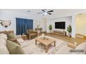 Bright, staged living room features contemporary furniture, a ceiling fan, neutral walls, and wood-look flooring at 1453 W Birch Rd, San Tan Valley, AZ 85140