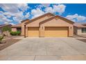 Spacious three-car garage with yellow doors and a wide concrete driveway, perfect for ample parking at 16609 N 40Th Dr, Phoenix, AZ 85053