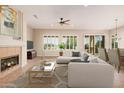 Bright living room with fireplace, neutral tones, large windows, and a comfortable sectional sofa at 16704 W Oracle Rim Dr, Surprise, AZ 85387