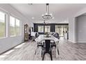 Open-concept dining area with wood-look tile flooring and modern chandelier, seamlessly connecting to the adjacent living spaces at 1914 N Marketside Ave, Buckeye, AZ 85396