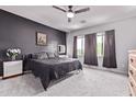 Comfortable main bedroom with a ceiling fan, neutral color scheme, carpeted floor, and natural light from multiple windows at 1914 N Marketside Ave, Buckeye, AZ 85396