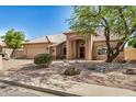 Charming single-story home showcasing desert landscaping, an attached garage, and a tile roof at 2226 N Gentry --, Mesa, AZ 85213