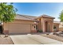 Single-story home featuring a spacious driveway, attached garage, clay tile roof, and desert landscaping at 2226 N Gentry --, Mesa, AZ 85213