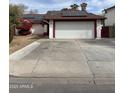 Front exterior view of a single-story house featuring a large driveway and solar panels on the roof at 2533 N 88Th Ln, Phoenix, AZ 85037
