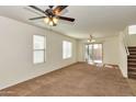 Bright living room with neutral carpet, access to back patio, staircase, and overhead lighting at 3535 E Erie St, Gilbert, AZ 85295