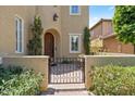 Elegant entryway with a wooden front door and gate, framed by manicured landscaping at 42 S Nevada Way, Gilbert, AZ 85233